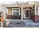 Charming front porch with dark wood door, brick accents, and white pillars at 1280 Galactic Pl, Castle Rock, CO 80108