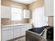 Well-lit laundry room with white cabinets, countertops, stainless steel appliances, and natural light from the window at 1280 Galactic Pl, Castle Rock, CO 80108