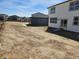 View of a new construction home's backyard, featuring new construction and neighboring houses, under a bright blue sky at 6071 Caribou Dr, Brighton, CO 80601