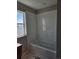 Modern bathroom featuring a tiled tub and shower, showcasing clean lines and ample natural light at 6071 Caribou Dr, Brighton, CO 80601
