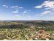 Gorgeous aerial view of a neighborhood surrounded by green hills and scattered homes under a beautiful blue sky with clouds at 6170 Falcon Ln, Morrison, CO 80465