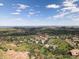 Stunning aerial view of a residential neighborhood nestled in rolling hills under a blue sky with scattered clouds at 6170 Falcon Ln, Morrison, CO 80465
