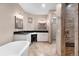 Spa-like bathroom featuring a soaking tub, dual sinks, and a stone-tiled shower at 6170 Falcon Ln, Morrison, CO 80465