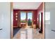 Bright bonus room with red accent wall, balcony access, and stunning floors at 6170 Falcon Ln, Morrison, CO 80465