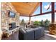 Covered deck with fireplace, TV, and comfortable seating at 6170 Falcon Ln, Morrison, CO 80465
