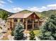 Two-story exterior elevation featuring brick accents and a walkout basement, all enhanced by the backdrop of green mountain views at 6170 Falcon Ln, Morrison, CO 80465