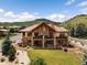 Beautiful two-story exterior elevation with brick accents, a cozy balcony, luscious green grass and mountain views at 6170 Falcon Ln, Morrison, CO 80465