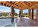 Covered patio with hot tub and stone columns perfect for outdoor gatherings at 6170 Falcon Ln, Morrison, CO 80465