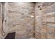 Close up of the shower with beautiful stone tile and built-in shower bench at 6170 Falcon Ln, Morrison, CO 80465