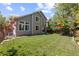 Expansive backyard with lush green grass, mature trees, and outdoor seating area at 16225 Peregrine Dr, Parker, CO 80134