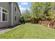 Well-maintained backyard featuring a lush lawn, mature trees, and a small patio set for outdoor enjoyment at 16225 Peregrine Dr, Parker, CO 80134