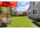 Spacious backyard showing the side of the home, with a small patio set and ample green space at 16225 Peregrine Dr, Parker, CO 80134