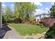 Spacious backyard with a lush lawn, mature trees, and a charming patio area at 16225 Peregrine Dr, Parker, CO 80134