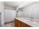 Bathroom featuring a double sink vanity, large mirror, and a shower with a white curtain at 16225 Peregrine Dr, Parker, CO 80134