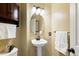 Cozy half bathroom with a pedestal sink, decorative mirror, and textured walls at 16225 Peregrine Dr, Parker, CO 80134