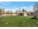 Spacious backyard featuring a covered patio, lush lawn, and privacy fencing at 6528 S Louthan St, Littleton, CO 80120