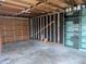 Spacious, unfinished garage featuring ample storage space and exposed wooden framing and door at 6528 S Louthan St, Littleton, CO 80120