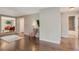 Open-concept living and dining area with hardwood floors and access to bathroom at 6528 S Louthan St, Littleton, CO 80120
