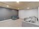Spacious carpeted basement with coffered ceiling and gray accent wall at 11420 E 1St Ave, Aurora, CO 80010