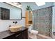Cozy bathroom with wood-like vessel sink, patterned shower curtain, and bright skylight at 11420 E 1St Ave, Aurora, CO 80010