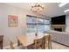 Bright dining room with natural light, a wooden table, and views of the living room and backyard at 11420 E 1St Ave, Aurora, CO 80010