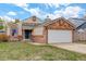 Charming single-Gathering home with brick accents, a green front door, and a two-car garage at 11420 E 1St Ave, Aurora, CO 80010