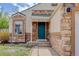 Close-up of front door with stone details and walkway at 11420 E 1St Ave, Aurora, CO 80010