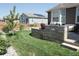 Landscaped backyard featuring a stone patio, lush lawn, and well-maintained wooden fence at 8371 S Cody Way, Littleton, CO 80128