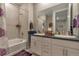 Bathroom with bath and shower combination and double vanity with dark countertops at 8371 S Cody Way, Littleton, CO 80128