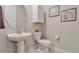 Powder room featuring pedestal sink, toilet and decorative artwork at 8371 S Cody Way, Littleton, CO 80128