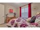 Bright bedroom featuring a wooden bed frame and large window with red curtains at 8371 S Cody Way, Littleton, CO 80128
