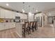 Bright kitchen featuring white cabinets, granite countertops, stainless steel appliances, and an island with barstool seating at 8371 S Cody Way, Littleton, CO 80128