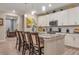 Modern kitchen with white cabinetry, granite countertops, stainless steel appliances, and a large island with bar seating at 8371 S Cody Way, Littleton, CO 80128