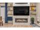 Modern living room with sleek fireplace, large TV, and floating shelves at 8371 S Cody Way, Littleton, CO 80128