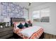 Bright bedroom with a trendy wallpaper, wood floors, and comfortable bed near a sunny window at 10864 Lyric St, Lone Tree, CO 80134