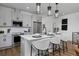 Modern kitchen features stainless steel appliances, gray cabinetry, pendant lighting, and a center island with barstool seating at 10864 Lyric St, Lone Tree, CO 80134