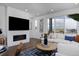 Open-concept living room features a fireplace, television, neutral furnishings, and sliding glass doors leading to a balcony at 10864 Lyric St, Lone Tree, CO 80134