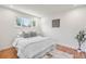 Bright bedroom featuring a white faux fur comforter, a window and hardwood floors at 111 Wolff St, Denver, CO 80219
