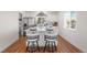 Stylish kitchen featuring an island with seating, stainless steel appliances, and wood flooring at 111 Wolff St, Denver, CO 80219