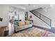 Open-concept living room with stylish decor, modern staircase, and seamless kitchen access at 3444 Navajo St # 10, Denver, CO 80211