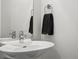 Modern powder room featuring a sleek white sink, contemporary fixtures, and a stylish towel rack at 3444 Navajo St # 10, Denver, CO 80211