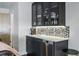 Wet bar with dark cabinetry, under-cabinet lighting, tile backsplash, sink, and stainless-steel dishwasher at 3444 Navajo St # 10, Denver, CO 80211