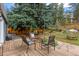 Cozy backyard deck with outdoor seating and mature trees, creating a serene and inviting space at 26095 Columbine Trl, Kittredge, CO 80457