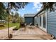 Backyard featuring a wooden deck with outdoor seating, flagstone patio, and low maintenance landscaping at 26095 Columbine Trl, Kittredge, CO 80457