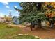 Spacious backyard with mature trees, a charming picnic bench, and multiple outdoor seating areas at 26095 Columbine Trl, Kittredge, CO 80457
