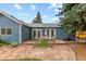 Backyard with a flagstone patio, outdoor dining area, garden beds, and manicured lawn at 26095 Columbine Trl, Kittredge, CO 80457