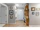 Hallway with laundry and coat rack, decorated with framed photos, and light-colored flooring at 26095 Columbine Trl, Kittredge, CO 80457