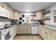U-shaped kitchen with granite counters, appliances, and light cabinets with under-cabinet lighting at 26095 Columbine Trl, Kittredge, CO 80457