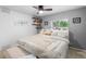 Comfortable main bedroom with modern ceiling fan, bright windows, and gray accent wall at 26095 Columbine Trl, Kittredge, CO 80457