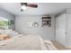 Well-lit main bedroom featuring a ceiling fan, floating shelves, and white closet door at 26095 Columbine Trl, Kittredge, CO 80457
